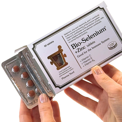 Hand holding a package of Bio-Selenium + Zinc tablets with visible branding.