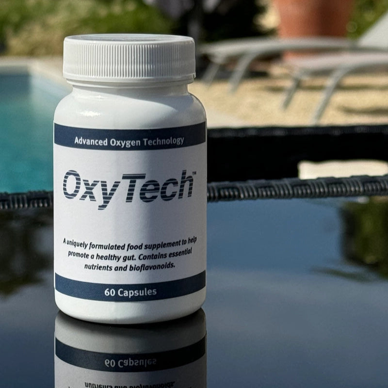 OxyTech supplement bottle on a reflective surface with a pool and chairs in the background