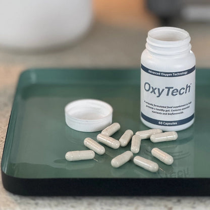 OxyTech 60 supplement bottle with capsules on a green tray