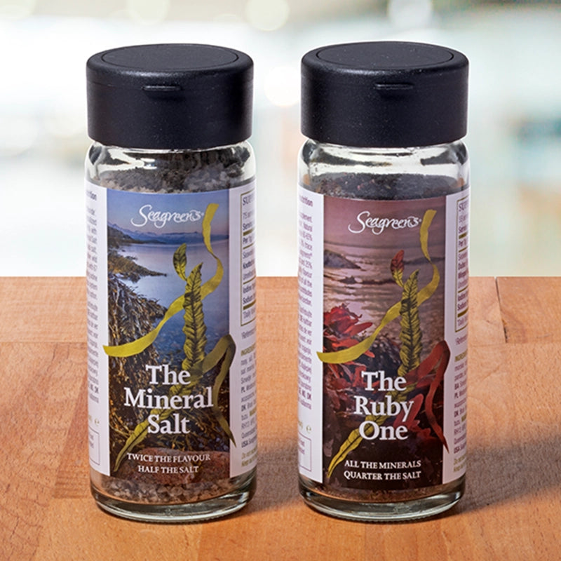 Two bottles of Seagreens Mineral Salt on a wooden surface with a blurred background