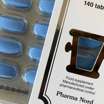 Blue tablets in a blister pack with a Pharma Nord bio-Glucosamine supplement container.